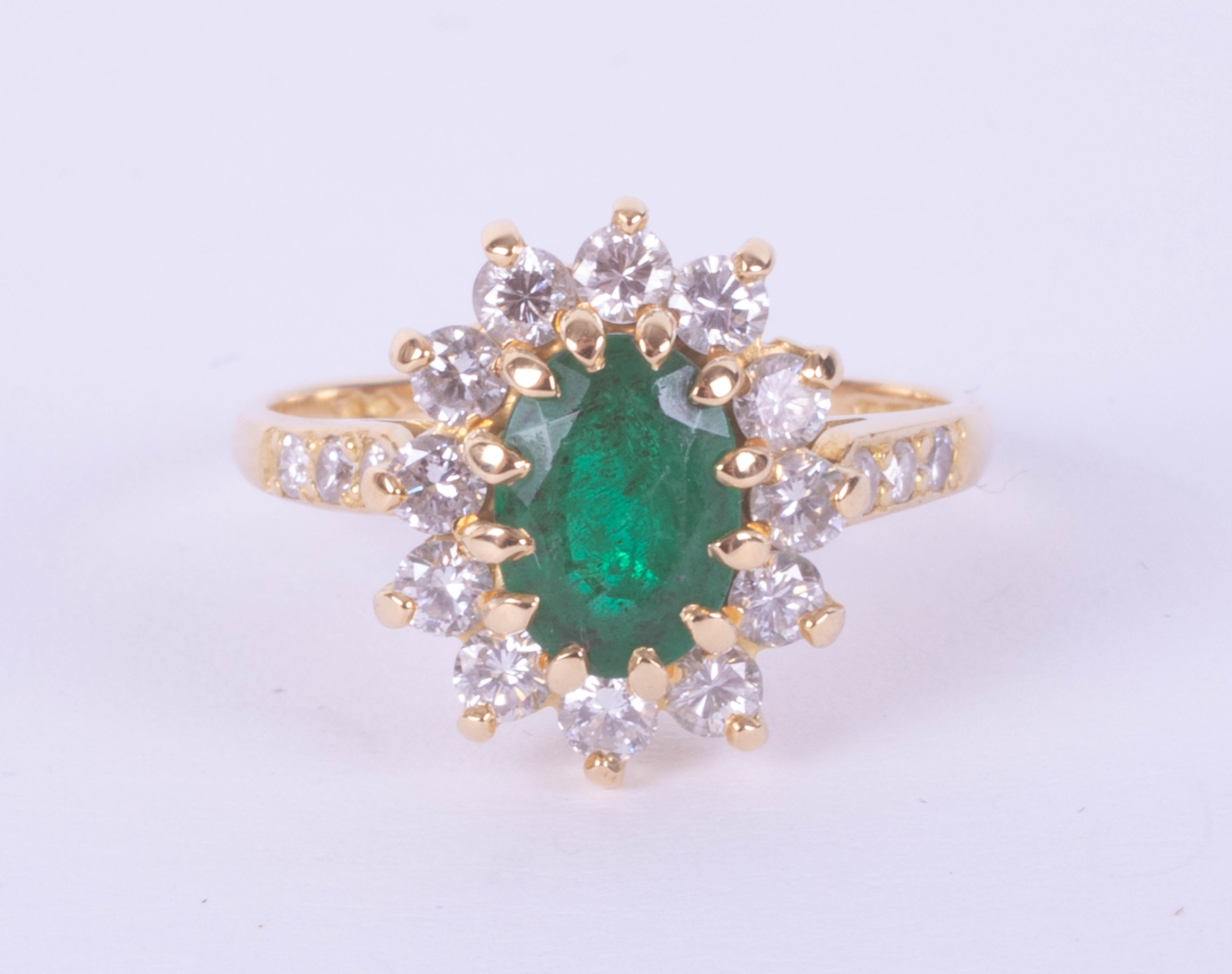 An 18ct yellow gold emerald and diamond oval cluster ring, size L.