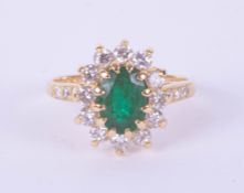 An 18ct yellow gold emerald and diamond oval cluster ring, size L.