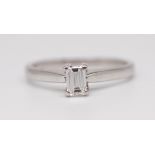 An 18ct white gold solitaire ring set with an emerald cut diamond approximately 0.25ct, size L.