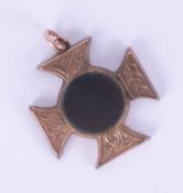 A 9ct gold cross fob with pinched hardstone enclosing a locket, width 25mm.