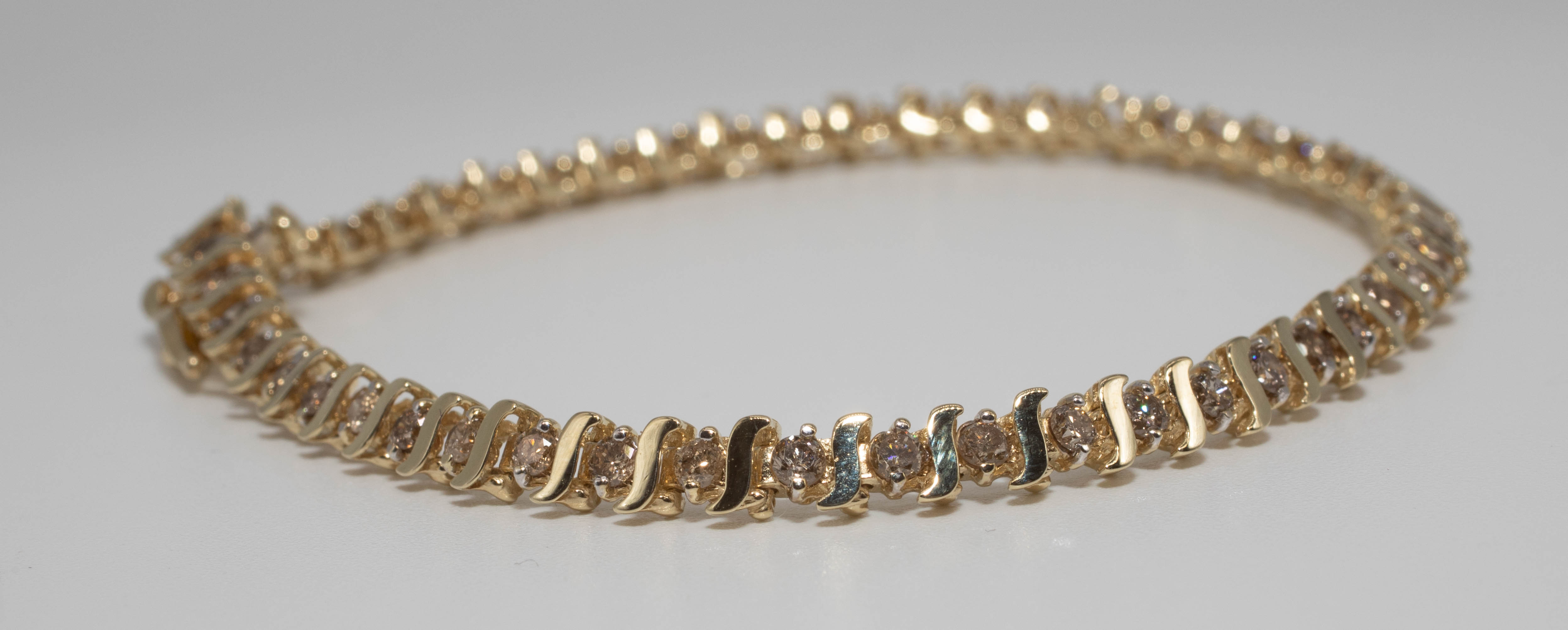 A diamond bracelet set in 10ct yellow gold, length 18cm.
