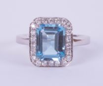 An 18ct white gold rectangular blue topaz and diamond cluster ring, size J.