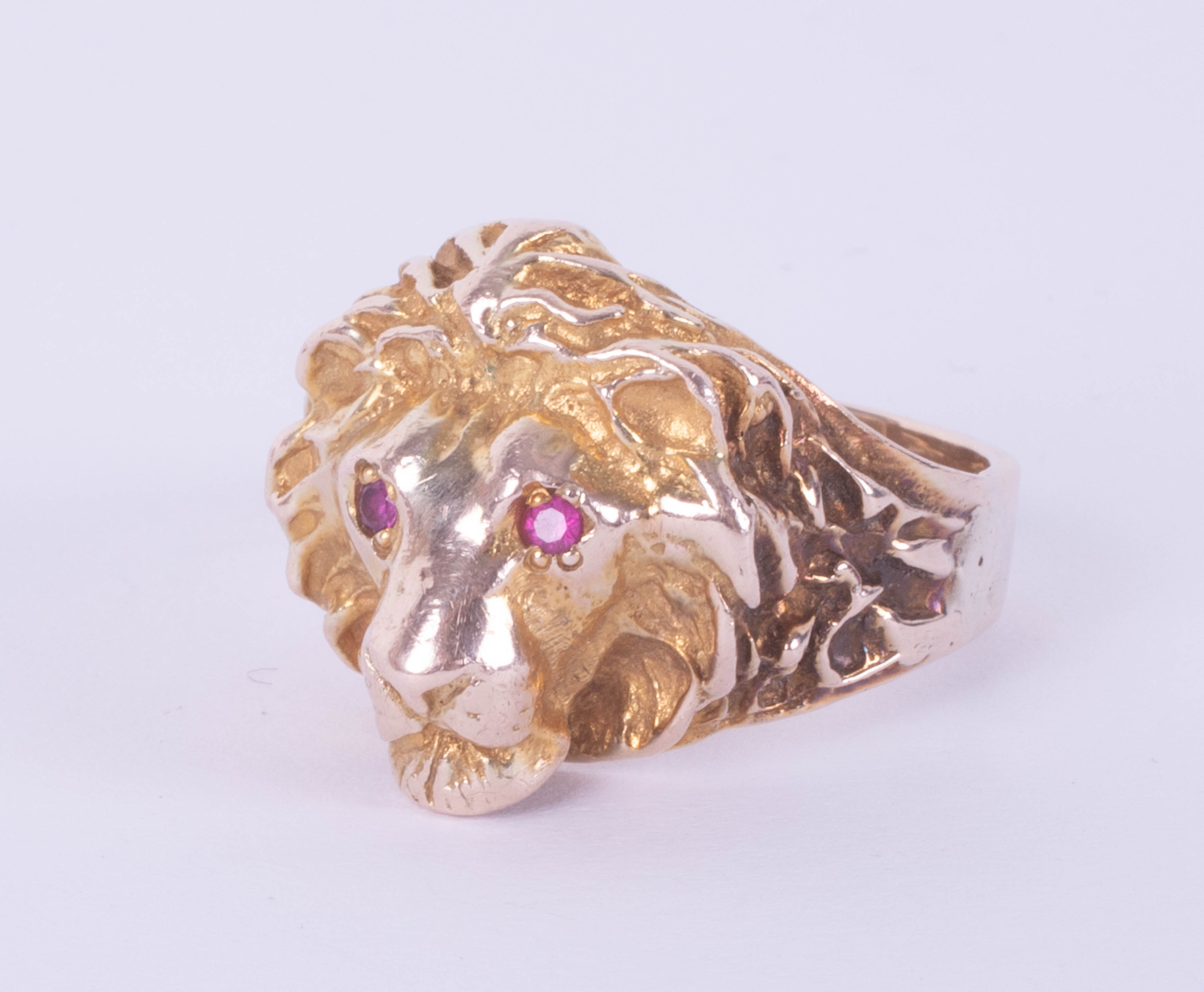 An impressive lion ring with ruby set eyes, yellow metal, 14g, unmarked, size X/Y.