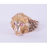 An impressive lion ring with ruby set eyes, yellow metal, 14g, unmarked, size X/Y.