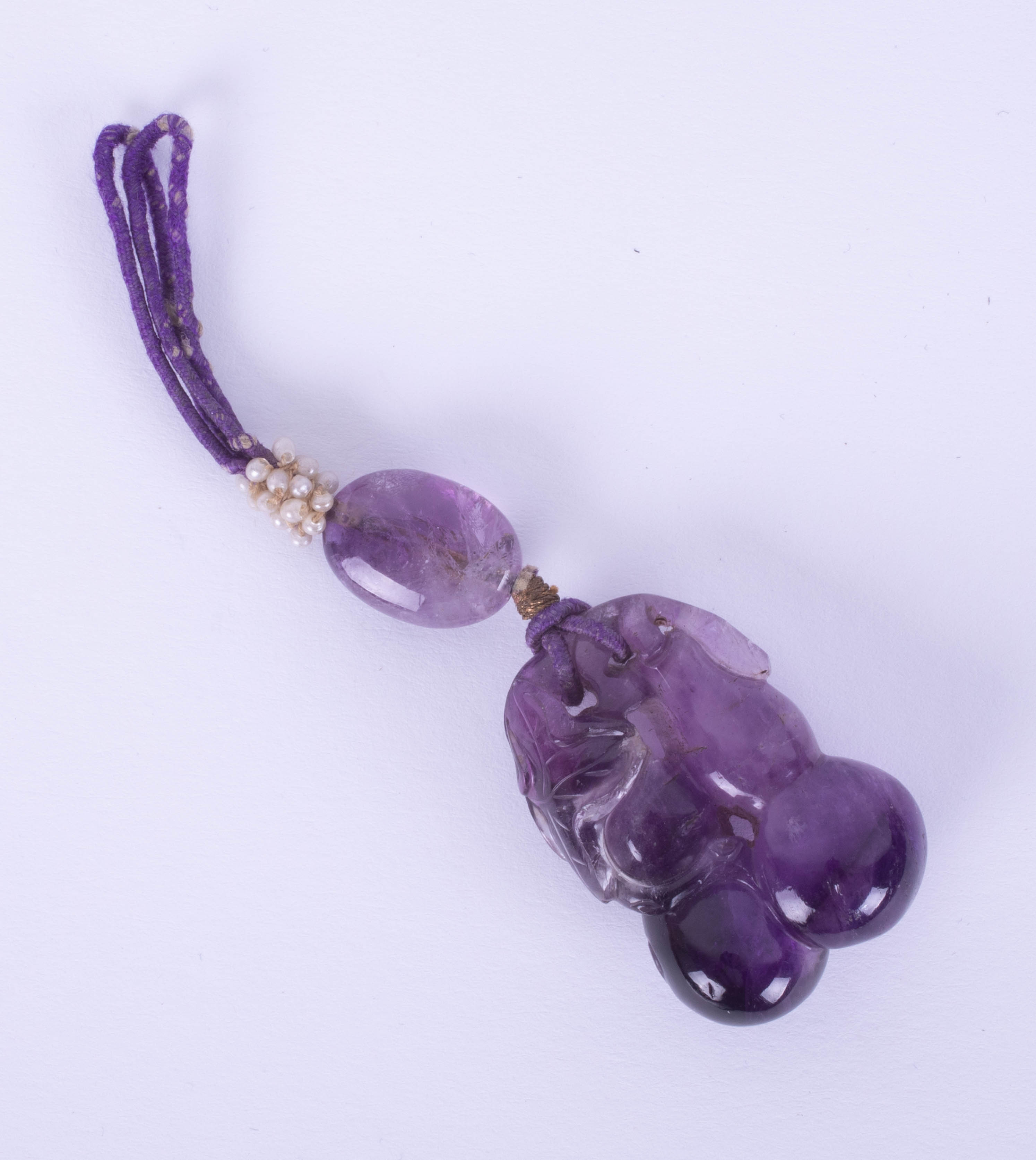 A large carved amethyst drop pendant, length of main carved stone 36mm, 23.35g.