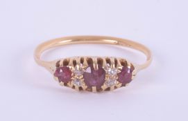 An 18ct ruby and diamond set seven stone ring, in yellow gold, size S.