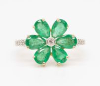 An 18ct emerald and diamond cluster ring in the form of a flower head set in yellow gold, size O.