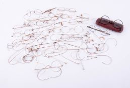 A 9ct gold pair of spectacles frames together with a collection of yellow metal spectacles without