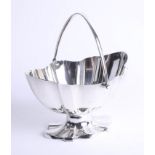 A silver oval fluted bowl with hinged handle and matching fluted foot, London, maker: HW, weight