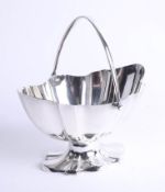 A silver oval fluted bowl with hinged handle and matching fluted foot, London, maker: HW, weight