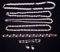 Five faux pearl necklaces and a pair of earrings.