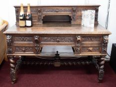 A Victorian heavily carved oak desk with upper section fitted with drawers over a base with