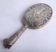 A foreign silver hand mirror with heavily embossed back and handle, replacement mirror required,