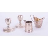 A pair of silver short desk candlesticks, silver cream jug and another, (weight of jug 113g).