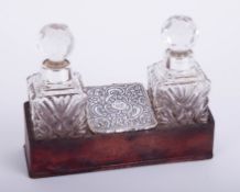 A pair of glass and silver mounted scent bottles, set in a stand, height 12cm including stopper.