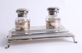 A silver continental ink and pen desk top stand on four splayed scroll feet, ink bottles with hinged