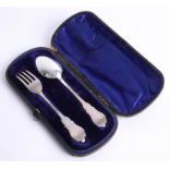 An antique Victorian christening spoon and fork with inlaid enamel boy and girl with blue velvet
