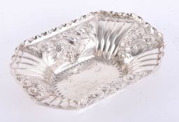 A silver rectangular dish with fluted corners and embossed scroll & foliate decoration, London maker