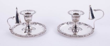 A matched pair of modern silver candlesticks, each with removable sconces and candle snuffers with