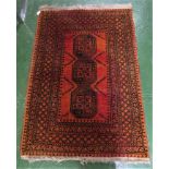 RUST RED GROUND PATTERNED FLOOR RUG WITH TASSELLED ENDS