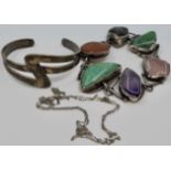 A bracelet of six irregular-shaped polished coloured stones mounted in white metal, stamped ST.SILV,