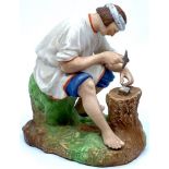 Russian Gardner bisque porcelain figure of seated workman in white smock, striking an object on a