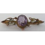 9 carat gold bar brooch set with a large amethyst (11mm x 10mm) and six seed pearls in scrolled leaf