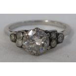 A platinum and diamond ring, the central brilliant cut stone estimated at 1.2ct, with three small