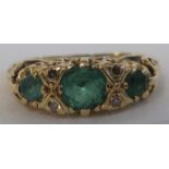 Gold dress ring set with a row of three graduated green stones (the largest 5mm x 4mm), spaced