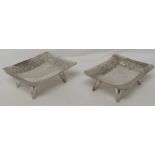 Pair of Indian silver-plated bon bon dishes, oblong with embossed borders, each raised on four