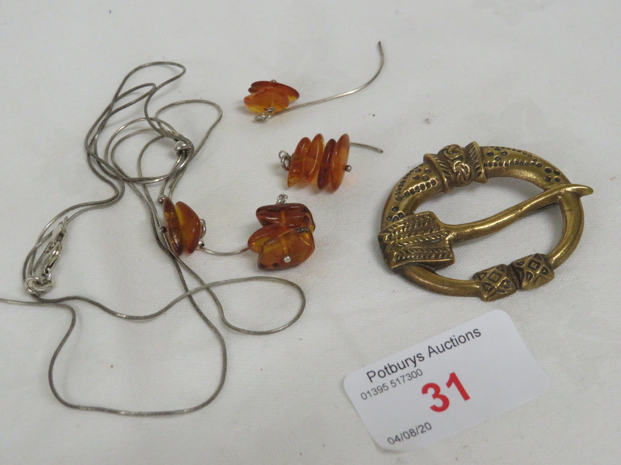 TWELVE AMBER PIECES ON A 925 WHITE METAL THREAD, AND A BROOCH STAMPED MADE IN FINLAND