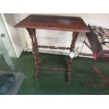 A small side table with a red wood rectangular top, oak frame with turned legs and stretchers,