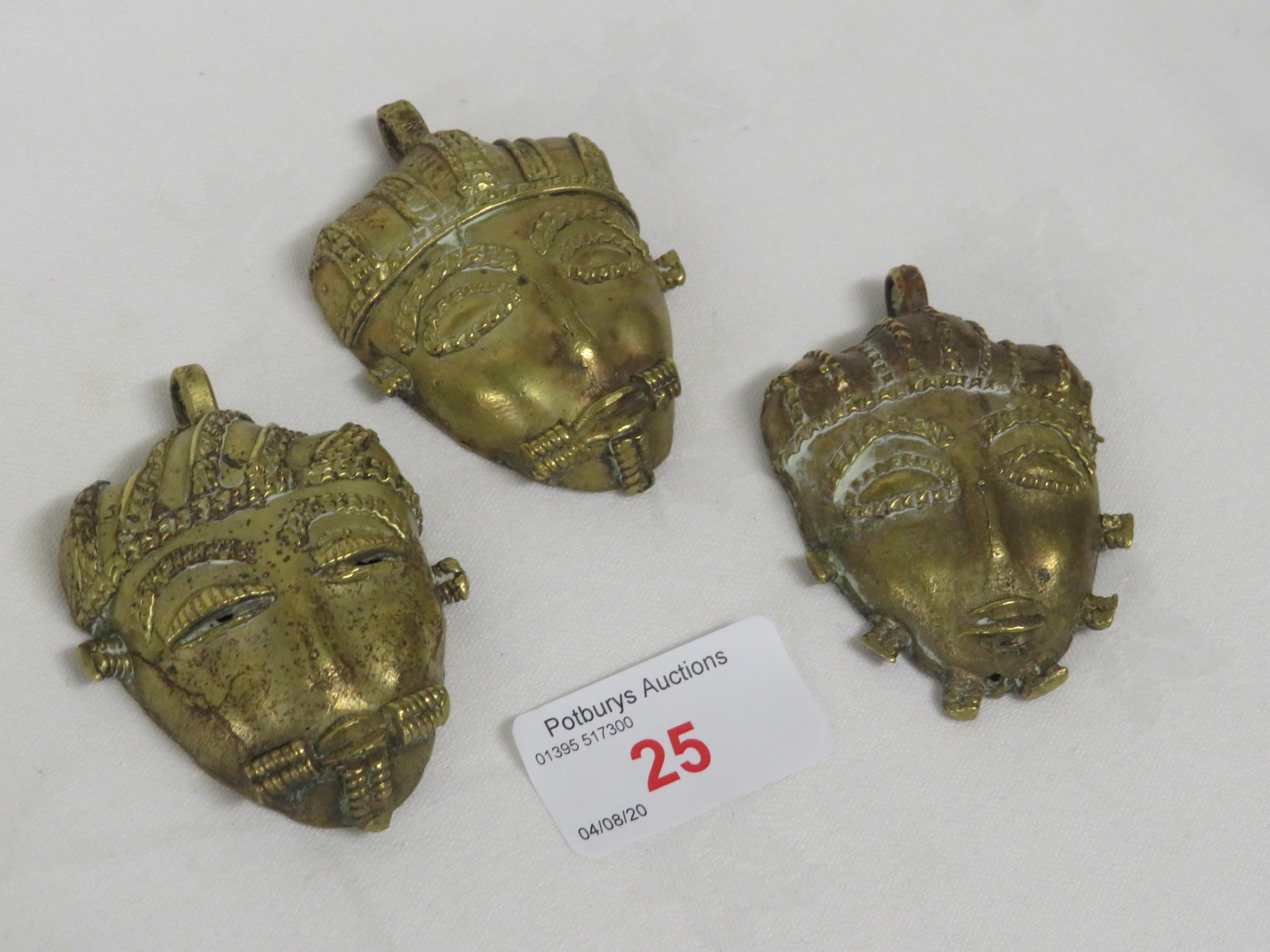 THREE ASHANTI BRASS FACE MASK PENDANTS, INDIVIDUALLY MADE