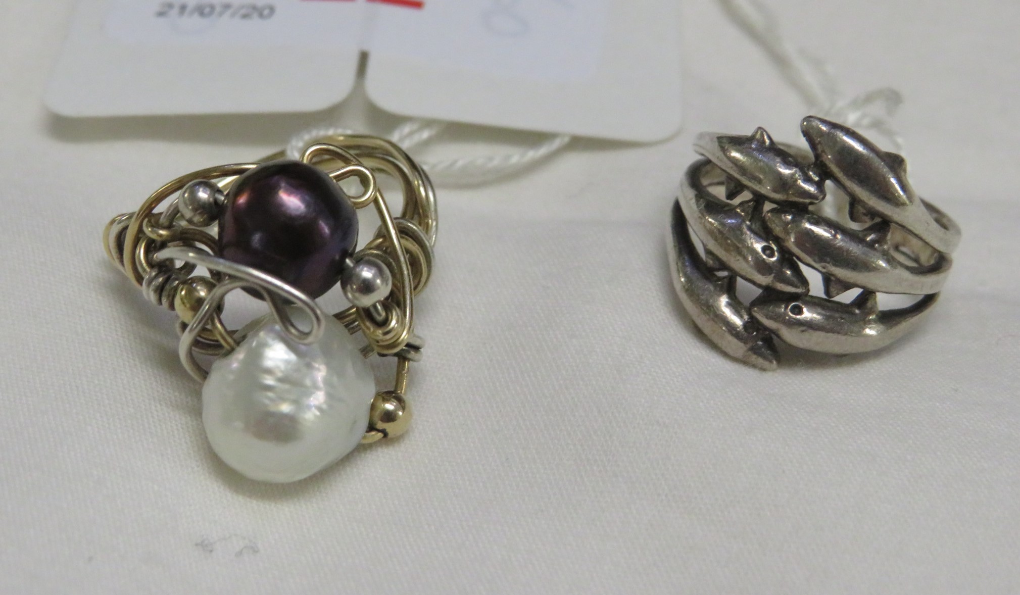 925 WHITE METAL RING IN THE FORM OF DOLPHINS, AND A WIRE RING WITH TWO PEARLS