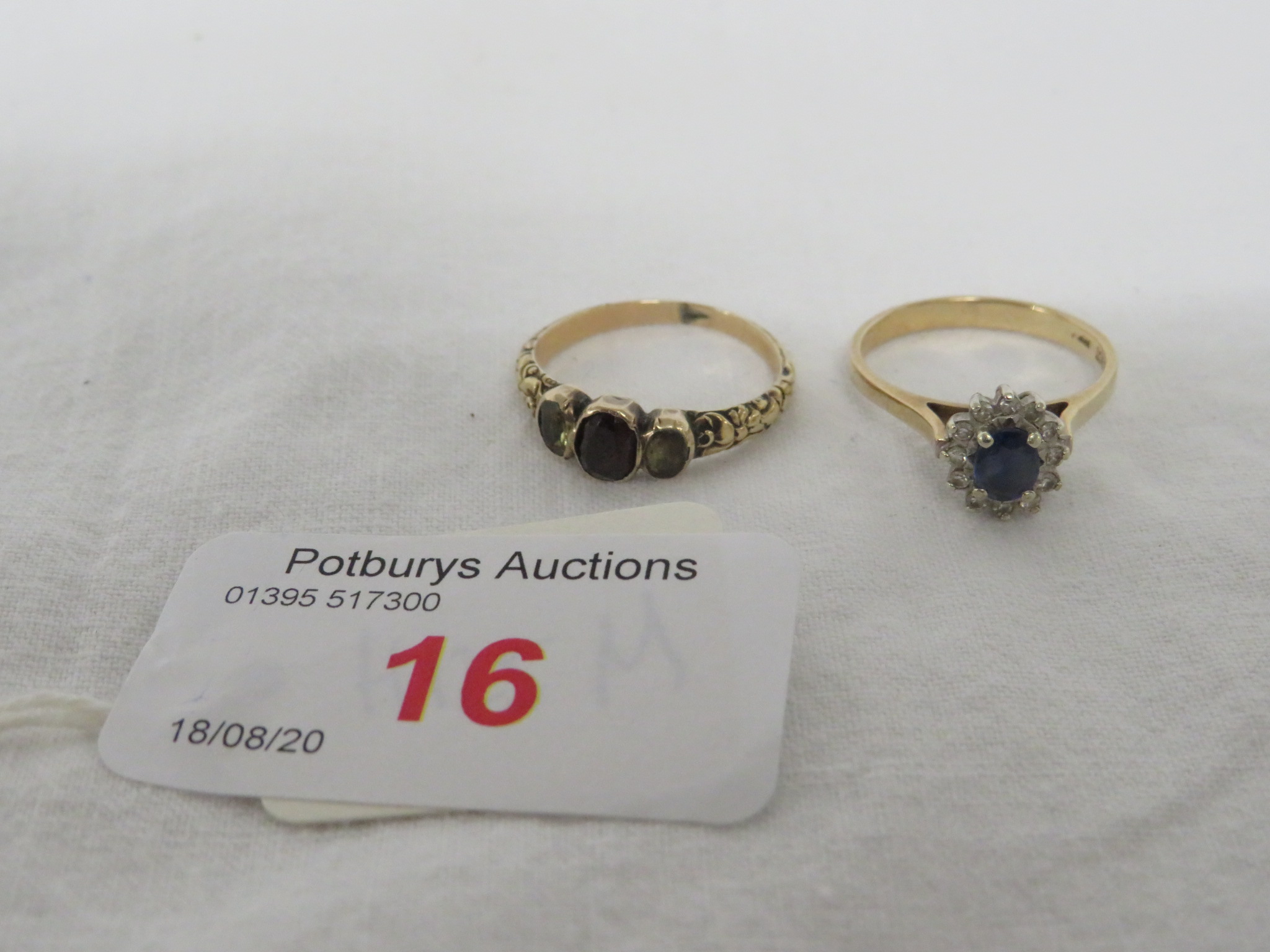 A DRESS RING SET WITH A SMALL SAPPHIRE (ABOUT 4.5MM X 3MM) SURROUNDED BY TWELVE VERY SMALL DIAMONDS,