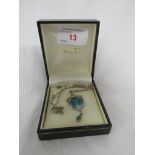 A JAMES FENTON SILVER AND BLUE-GREEN ENAMEL ART NOUVEAU STYLE PENDANT WITH TWO STYLISED FLOWER STEMS