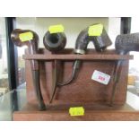 FOUR WOODEN TOBACCO PIPES ON PIPESTAND
