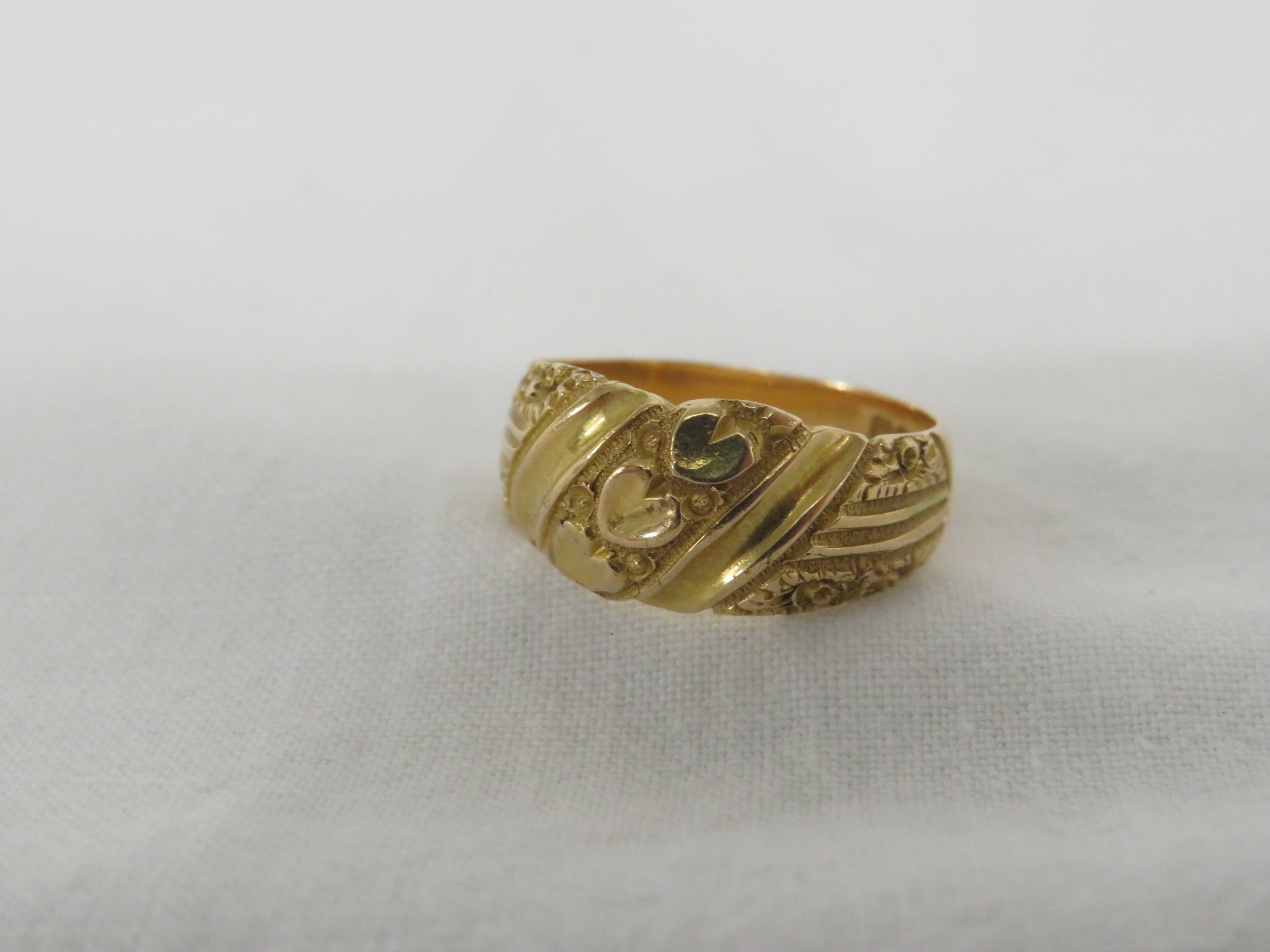 18 CARAT GOLD RING ENGRAVED WITH A ROW OF THREE HEARTS AND FOLIAGE, BRITISH HALLMARKS, 5.8G, WITH - Image 2 of 3