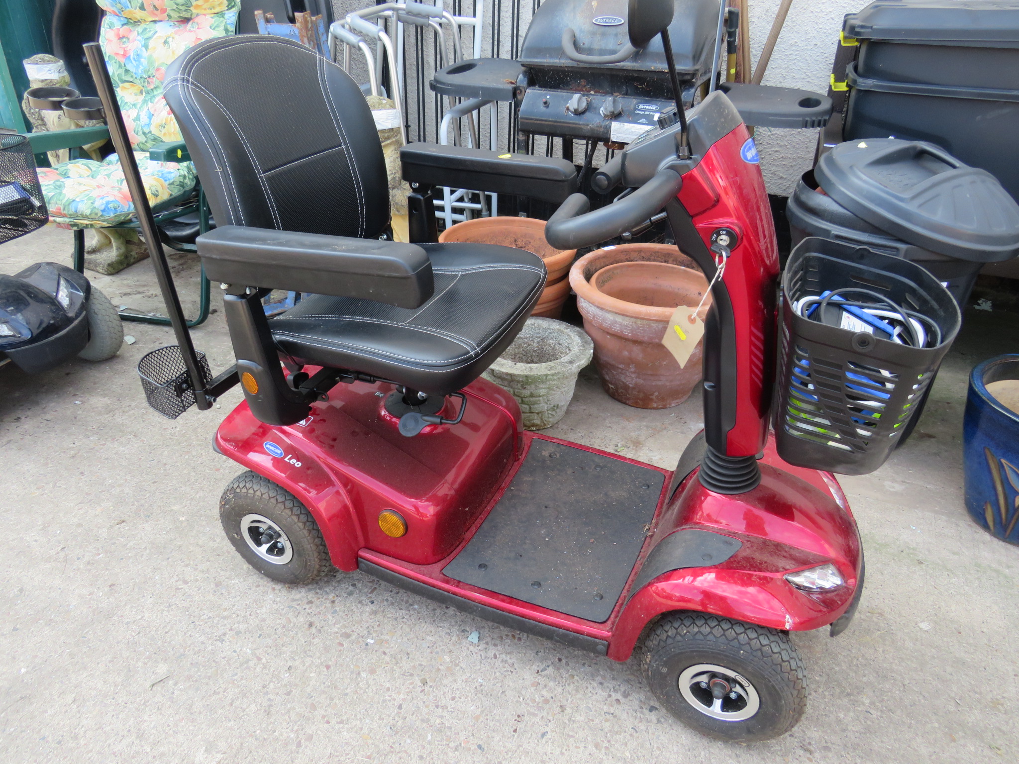 INVACARE LEO RED FOUR WHEEL MOBILITY SCOOTER, WITH KEY, BATTERY CHARGER AND USER MANUAL