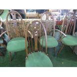 A SET OF FOUR ERCOL MID ELM STICK BACK DINING CHAIRS WITH PIERCED SWAN DECORATION, WITH GREEN SEAT