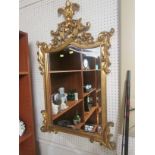 REPRODUCTION SHAPED WALL MIRROR IN A GILT WOOD FRAME CARVED WITH ACANTHUS LEAVES