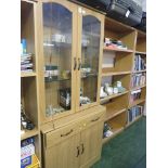 LIGHT WOOD EFFECT GLAZED AND ILLUMINATED CABINET WITH DRAWERS AND CUPBOARD TO BASE