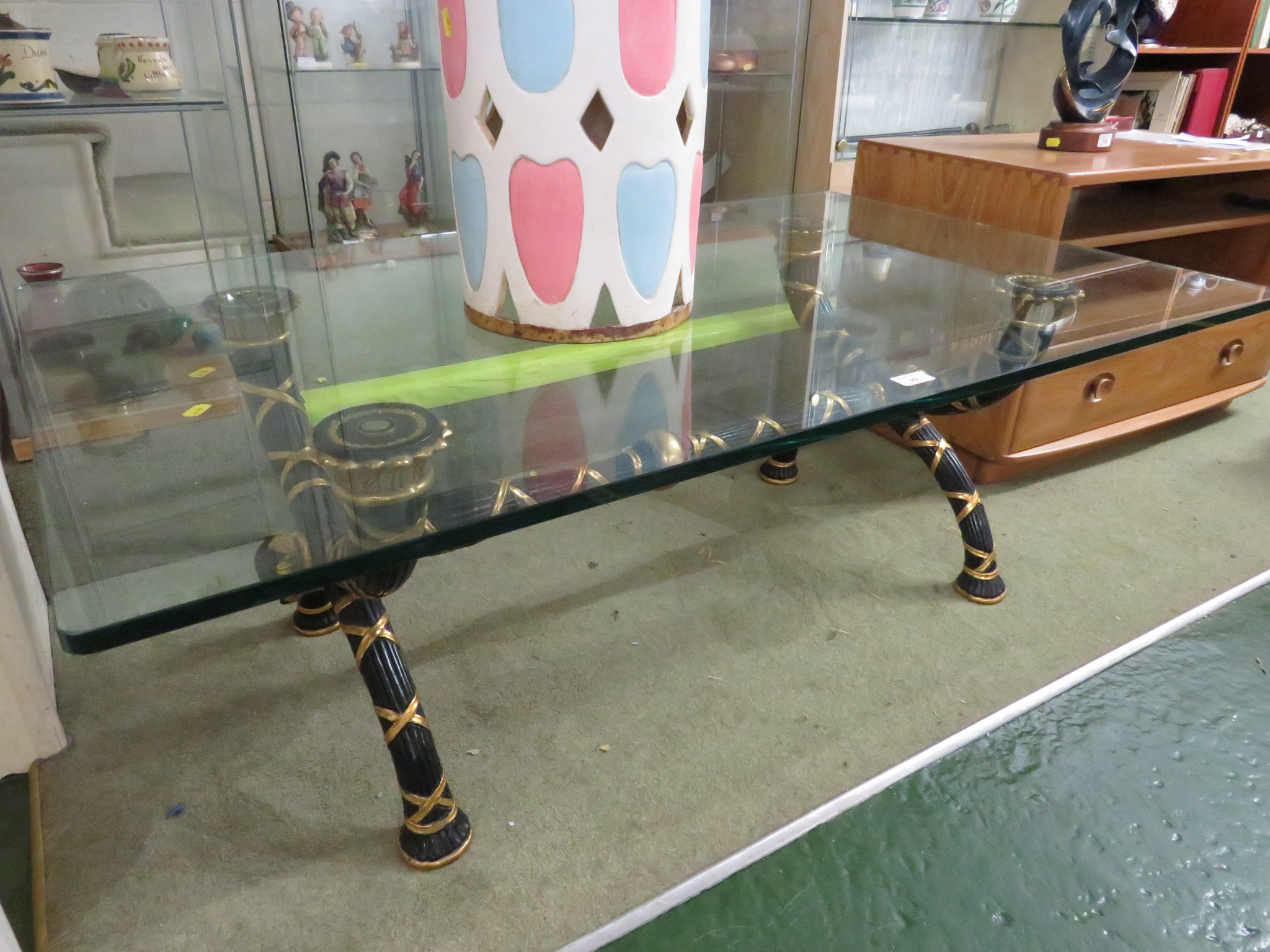 HEAVY GLASS RECTANGULAR COFFEE TABLE ON DECORATIVE BLACK PAINTED AND GILT X FRAME.