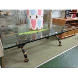 HEAVY GLASS RECTANGULAR COFFEE TABLE ON DECORATIVE BLACK PAINTED AND GILT X FRAME.