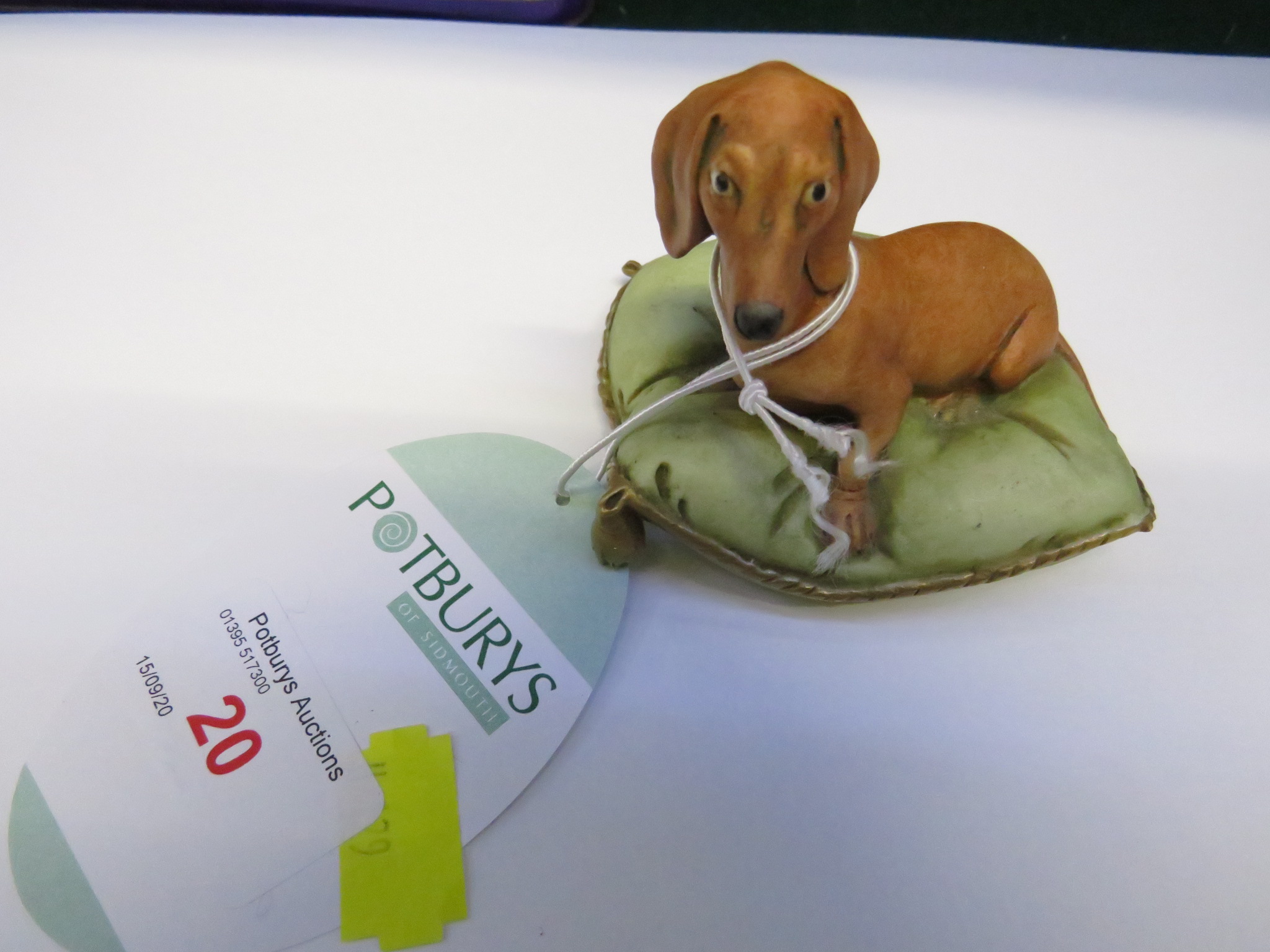 ITALIAN PORCELAIN FIGURINE OF DOG ON CUSHION.