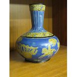 A FAR EASTERN POTTERY BOTTLE VASE IN BLUE AND BUFF GLAZE AND DECORATED WITH HORSEMEN AND