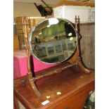 Oval frameless swing mirror on turned oak stand.