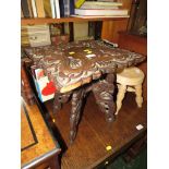 FAR EASTERN DARK WOOD FOLDING STOOL, HEAVILY CARVED WITH DRAGONS AND SERPENTS