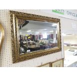 BEVELLED RECTANGULAR WALL MIRROR IN A PIERCED GILT FRAME