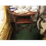 An oak oval topped two tier side table on turned supports.